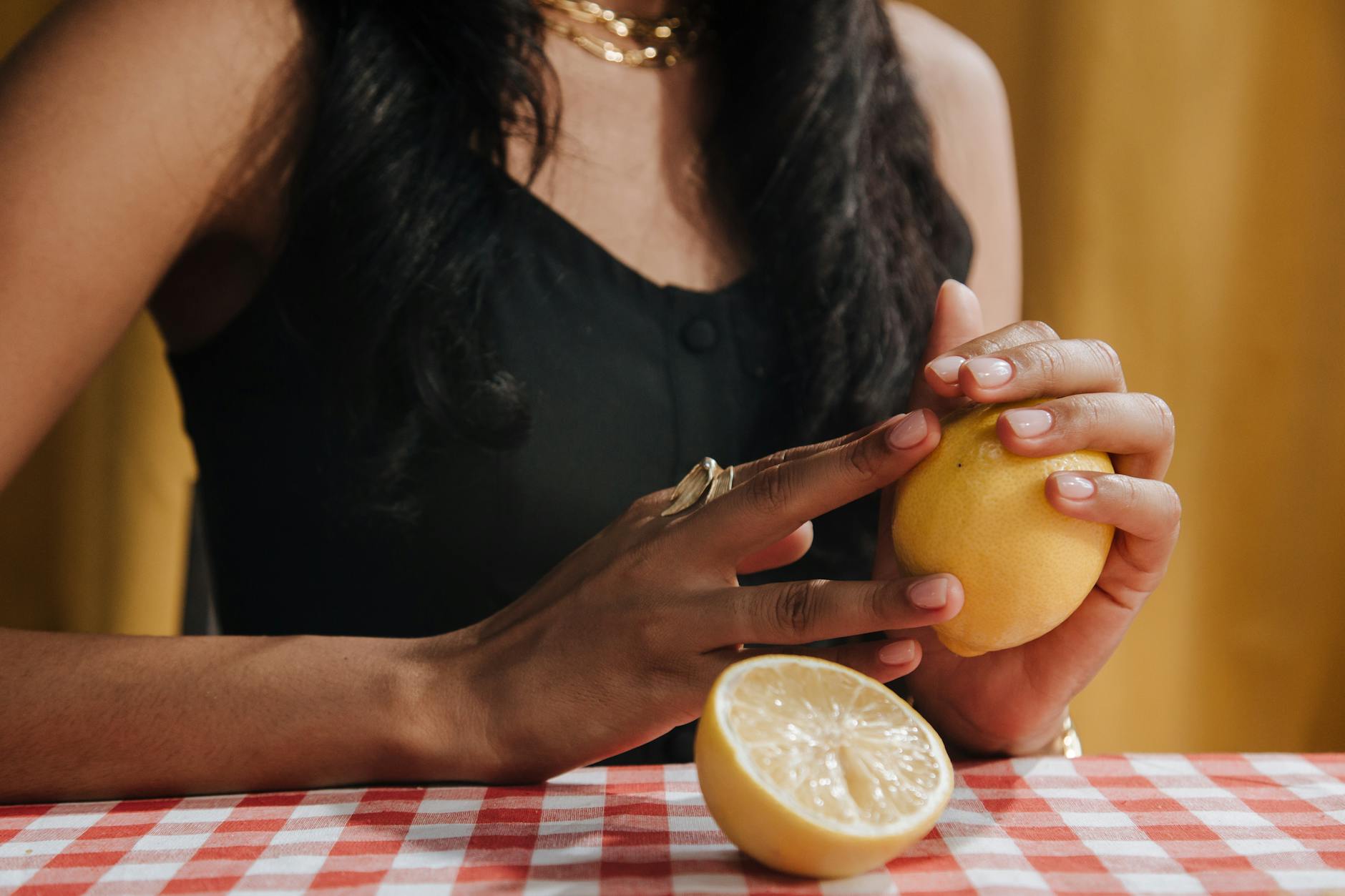 Two fresh lemons held in cupped hands on a brown surface, symbolizing restored sensation and vitality
