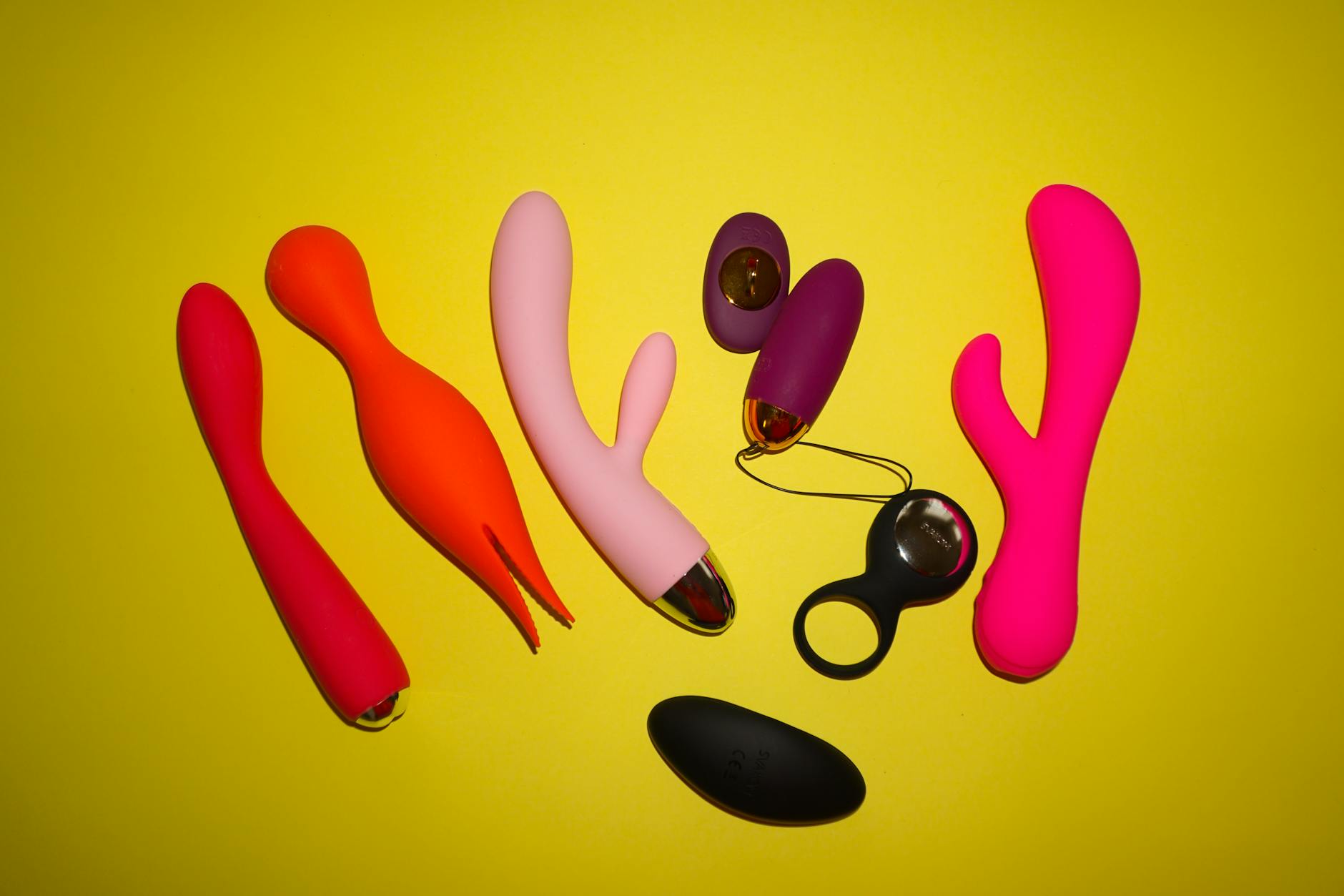 Hand holding blue silicone vibrator against purple background during recovery journey